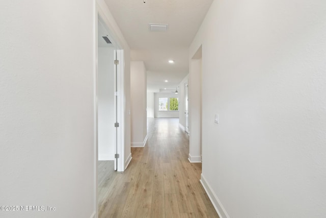 corridor with light hardwood / wood-style floors