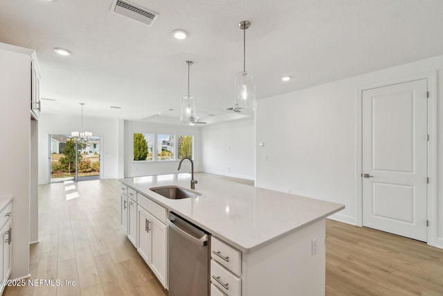 kitchen with white cabinetry, dishwasher, sink, and a center island with sink