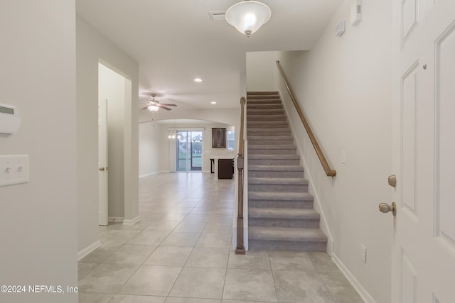 stairway with tile patterned flooring and ceiling fan