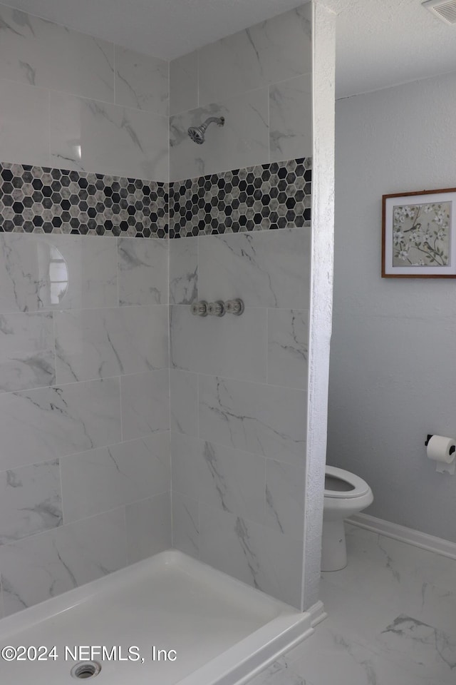 3037 Ribault Scenic Dr, Jacksonville, FL 32208 - bathroom with toilet, tiled shower, marble finish floor, baseboards, and visible vents