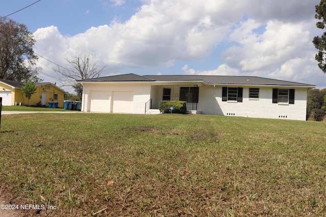 3037 Ribault Scenic Dr, Jacksonville, FL 32208 - ranch-style home featuring driveway, brick siding, a front lawn, metal roof, and a garage