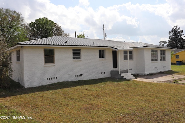 3037 Ribault Scenic Dr, Jacksonville, FL 32208 - back of property with a lawn, metal roof, crawl space, and brick siding