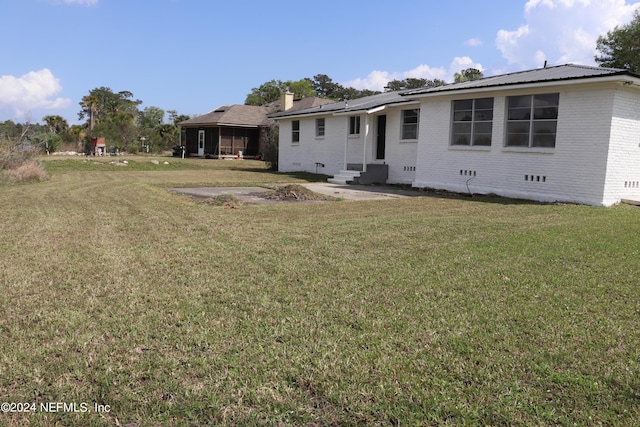 3037 Ribault Scenic Dr, Jacksonville, FL 32208 - rear view of property with entry steps, a chimney, crawl space, brick siding, and a yard