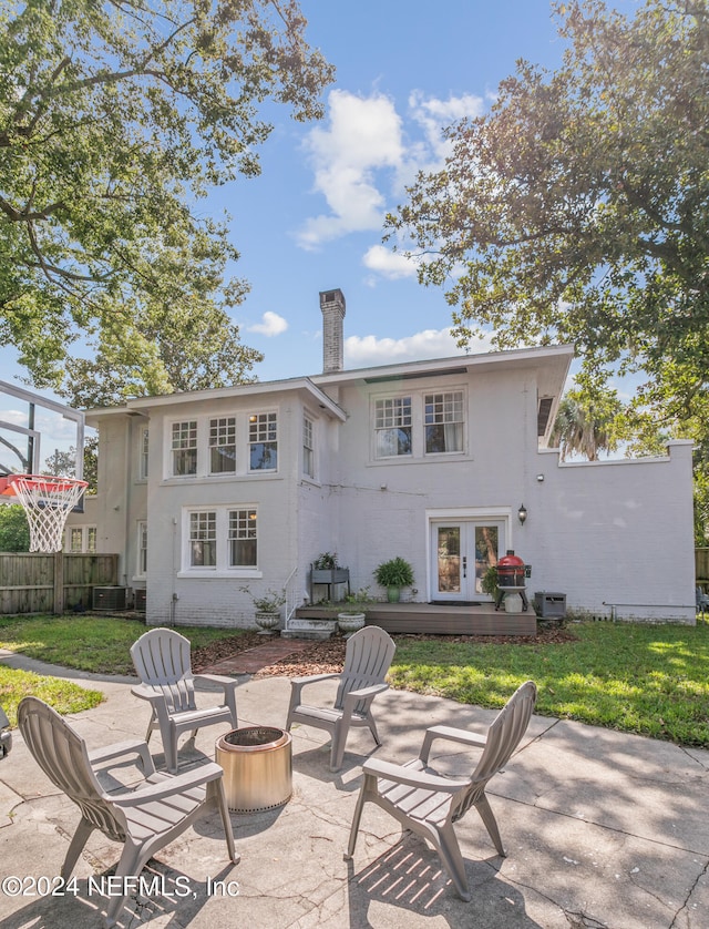 back of house with a lawn, a patio area, and an outdoor fire pit