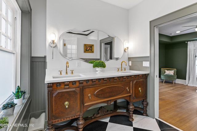 bathroom with ceiling fan, dual vanity, and hardwood / wood-style flooring