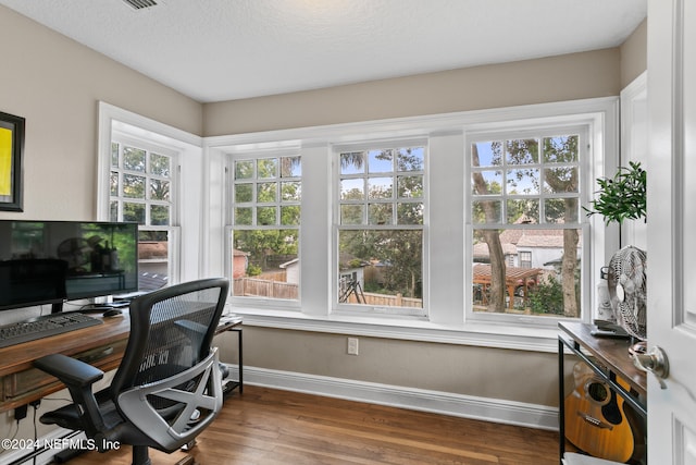 office with plenty of natural light and hardwood / wood-style flooring