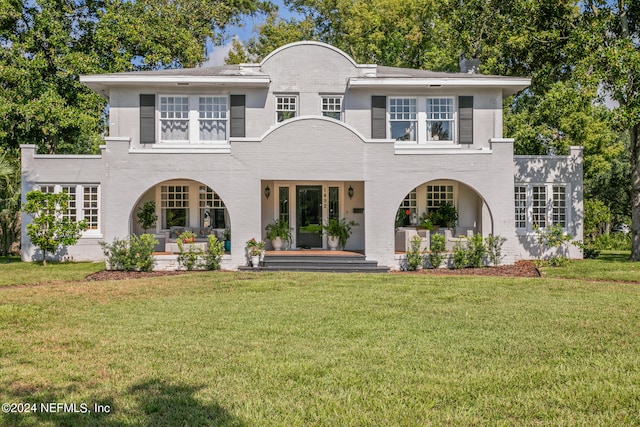 rear view of property featuring a lawn