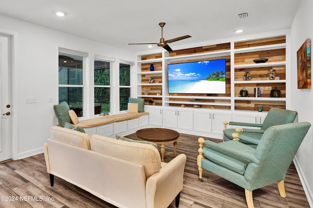 living room with visible vents, built in shelves, wood finished floors, recessed lighting, and ceiling fan