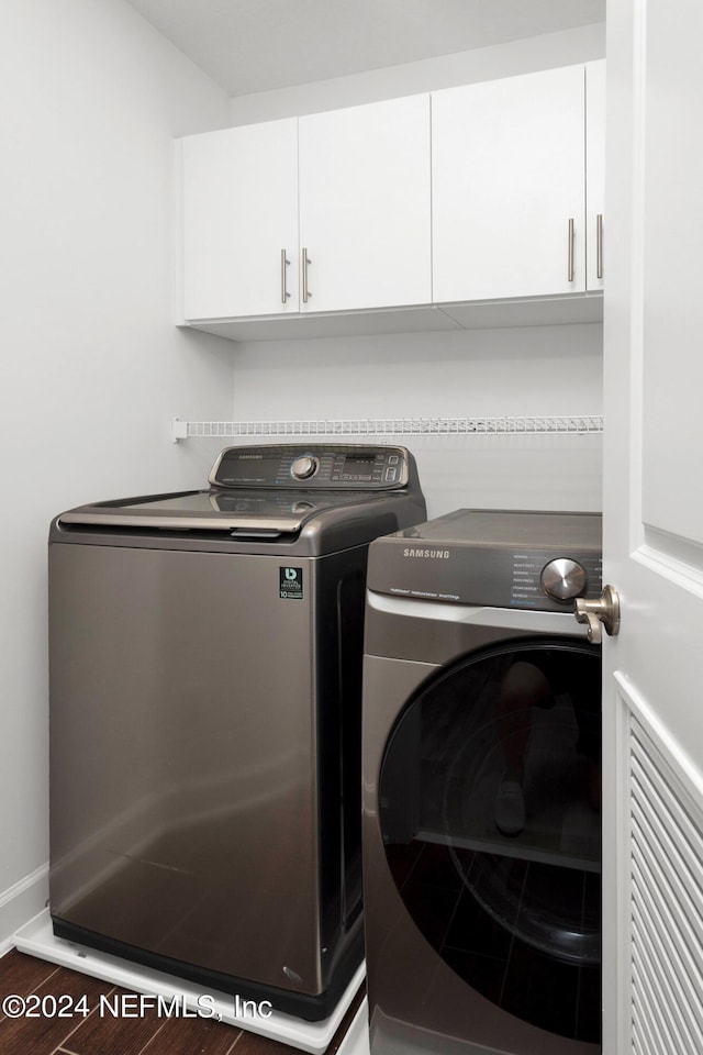 laundry room with wood finished floors, cabinet space, and washing machine and clothes dryer