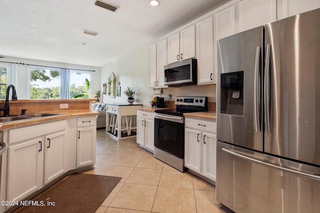 kitchen with white cabinetry, sink, and stainless steel appliances