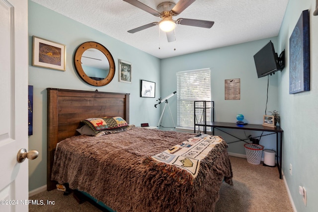 carpeted bedroom featuring ceiling fan and a textured ceiling