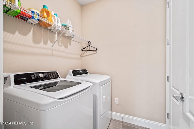 washroom with light tile patterned floors and washer and clothes dryer