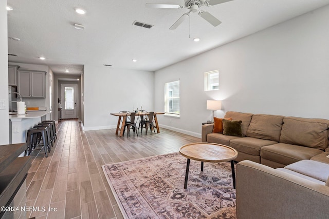 living room featuring ceiling fan and light hardwood / wood-style floors