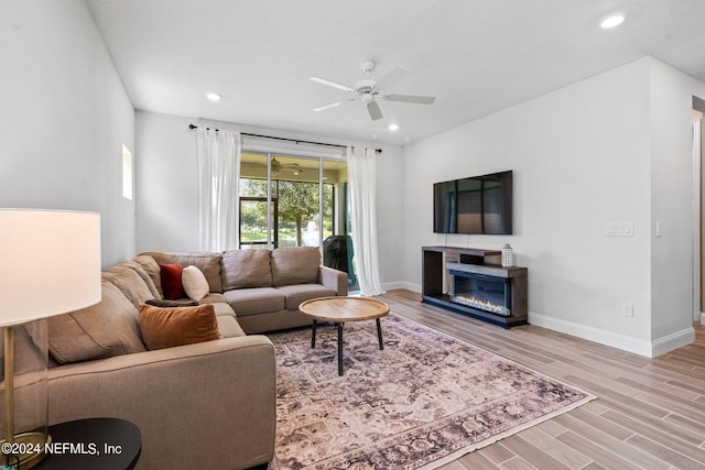 living room with ceiling fan and light wood-type flooring