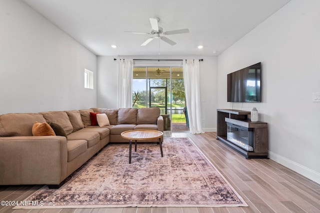 living room featuring ceiling fan and hardwood / wood-style flooring