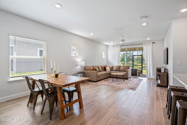 dining room featuring ceiling fan, a wealth of natural light, and light hardwood / wood-style flooring