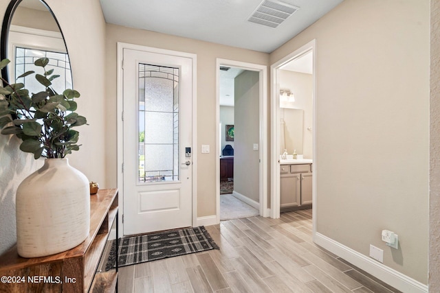 doorway to outside featuring light wood-type flooring and sink