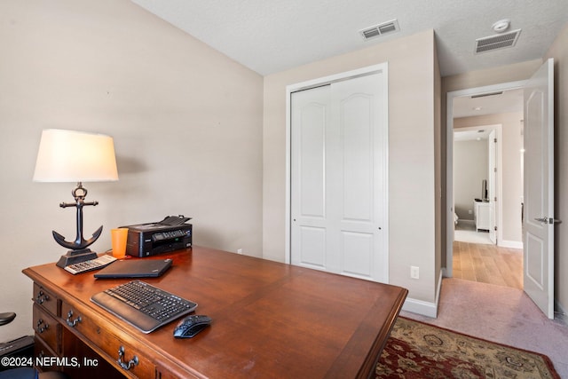 carpeted office space featuring a textured ceiling