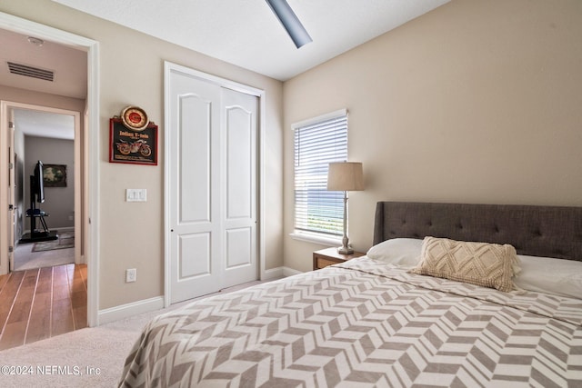 carpeted bedroom featuring ceiling fan and a closet