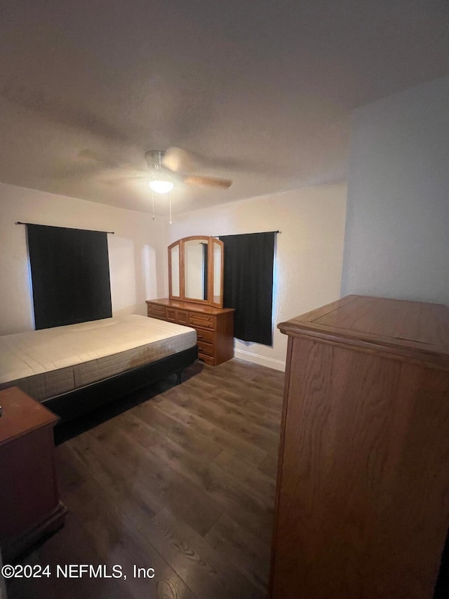 unfurnished bedroom featuring ceiling fan and dark hardwood / wood-style floors