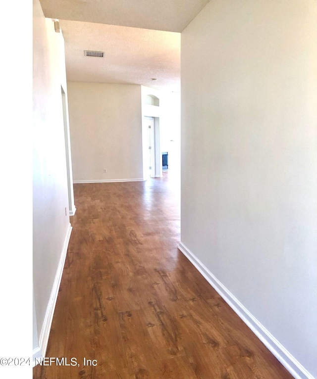 corridor with dark hardwood / wood-style flooring