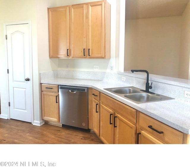 kitchen with light brown cabinetry, sink, light stone countertops, hardwood / wood-style flooring, and stainless steel dishwasher