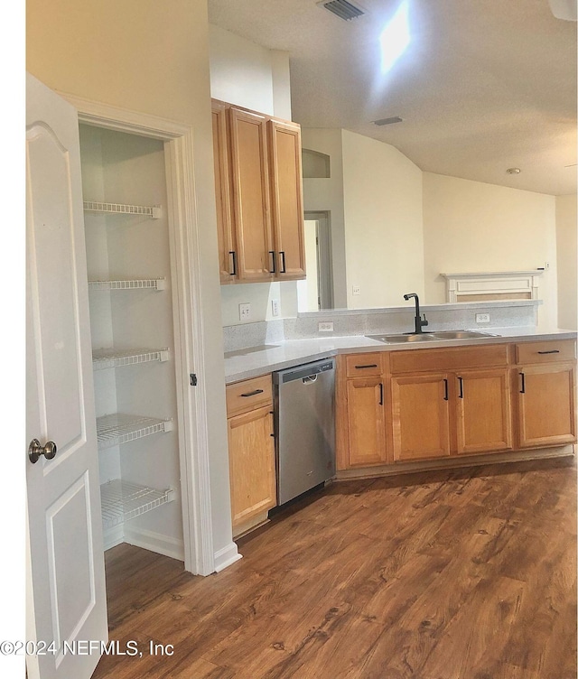 kitchen with lofted ceiling, stainless steel dishwasher, sink, and dark hardwood / wood-style floors