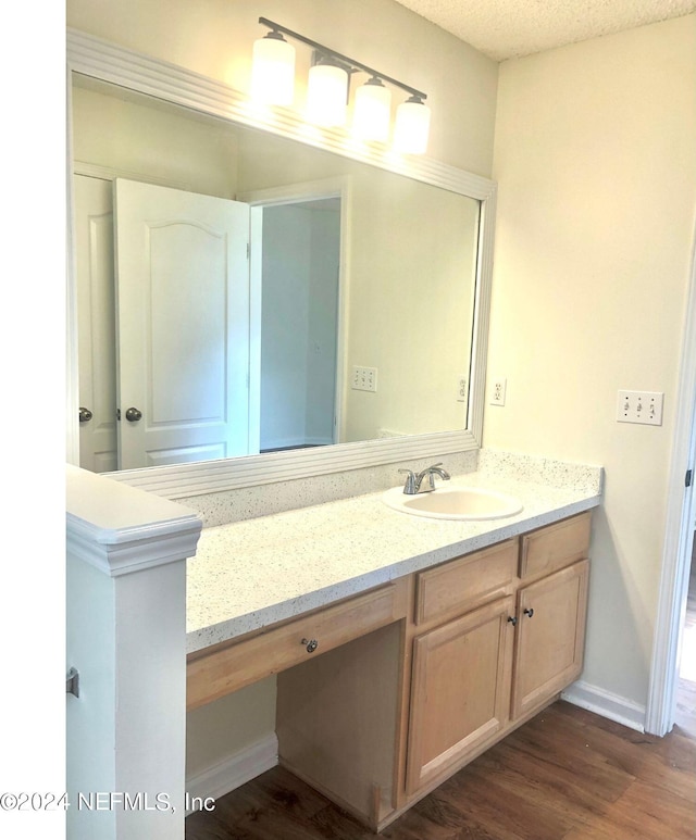 bathroom with hardwood / wood-style floors, a textured ceiling, and vanity