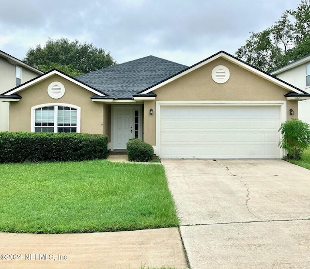 view of front of house featuring a garage and a front lawn