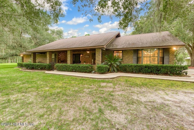 ranch-style house featuring a front yard and brick siding