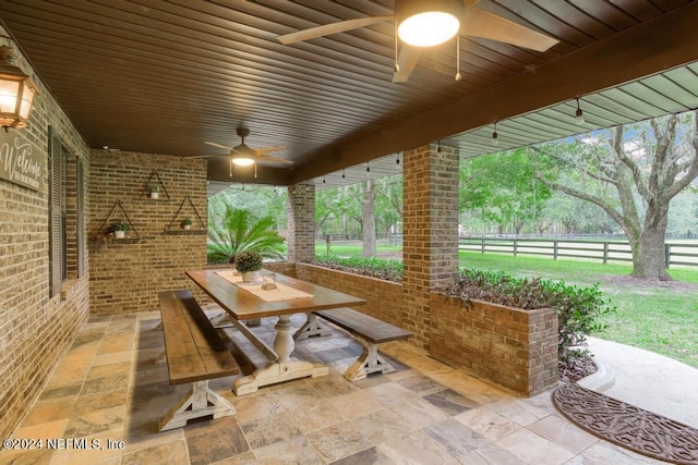 view of patio featuring outdoor dining area, fence, and ceiling fan