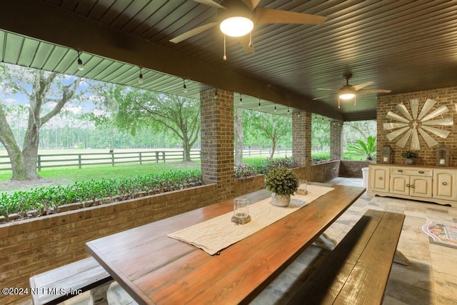 view of patio featuring outdoor dining area, fence, and a ceiling fan