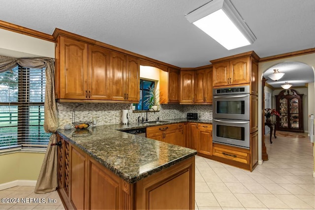 kitchen featuring light tile patterned floors, ornamental molding, sink, decorative backsplash, and double oven