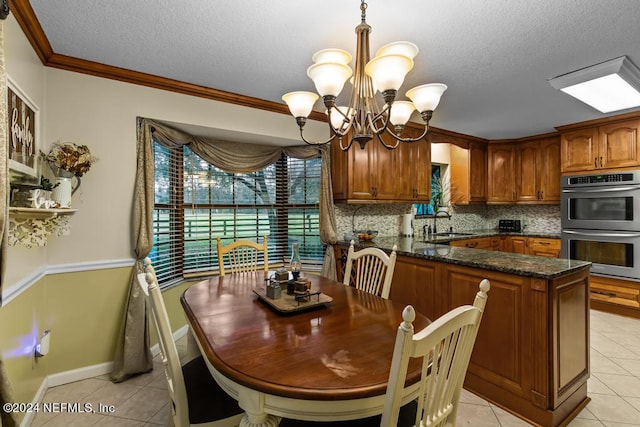 kitchen featuring a notable chandelier, light tile patterned floors, crown molding, decorative backsplash, and stainless steel double oven