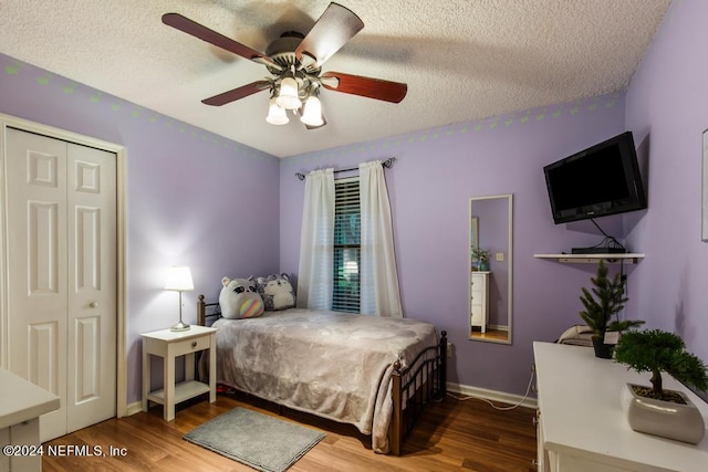 bedroom with a closet, ceiling fan, hardwood / wood-style flooring, and a textured ceiling