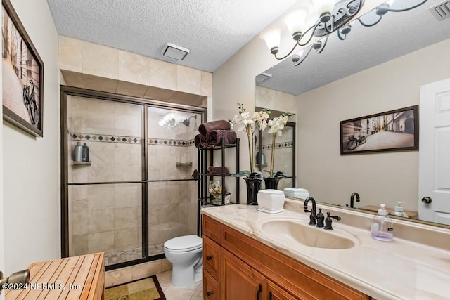 full bathroom featuring vanity, a textured ceiling, toilet, and a shower stall