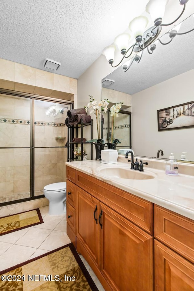 bathroom with toilet, an enclosed shower, tile patterned flooring, vanity, and a textured ceiling