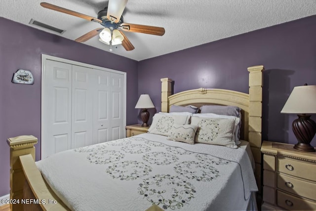bedroom with a closet, a textured ceiling, visible vents, and a ceiling fan