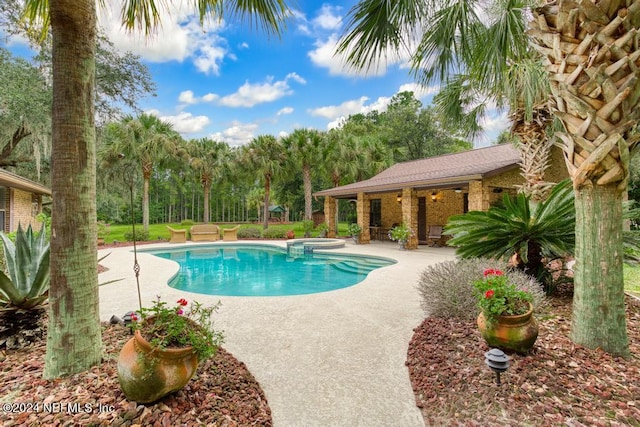 view of swimming pool featuring a pool with connected hot tub and a patio