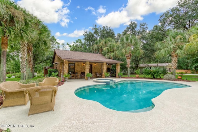 view of swimming pool with a pool with connected hot tub, an outdoor structure, outdoor dry bar, and a patio
