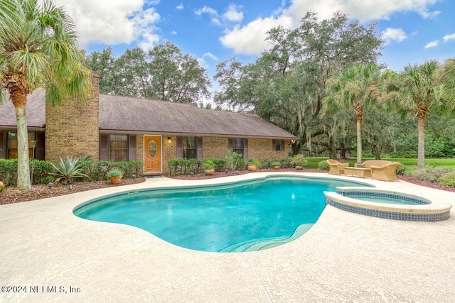 view of swimming pool featuring an in ground hot tub and a patio