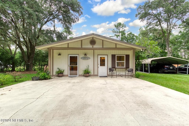 view of front of house featuring a front lawn and a detached carport