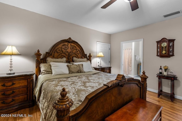 bedroom with ceiling fan, ensuite bath, and wood-type flooring