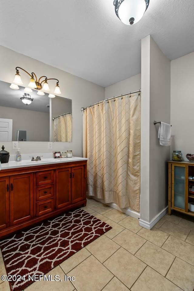 bathroom featuring tile patterned flooring, vanity, and a textured ceiling