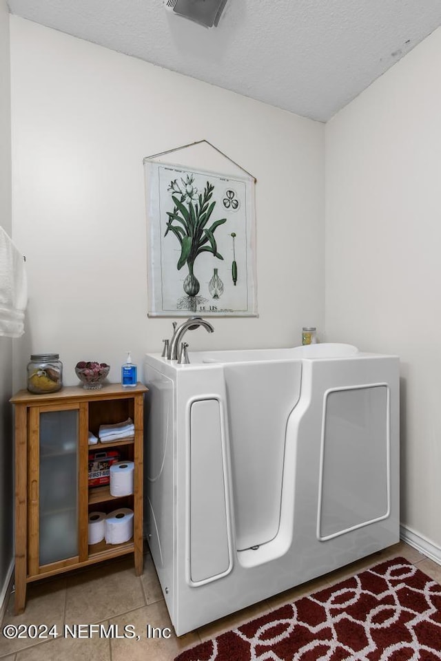 laundry room with light tile patterned floors and a textured ceiling