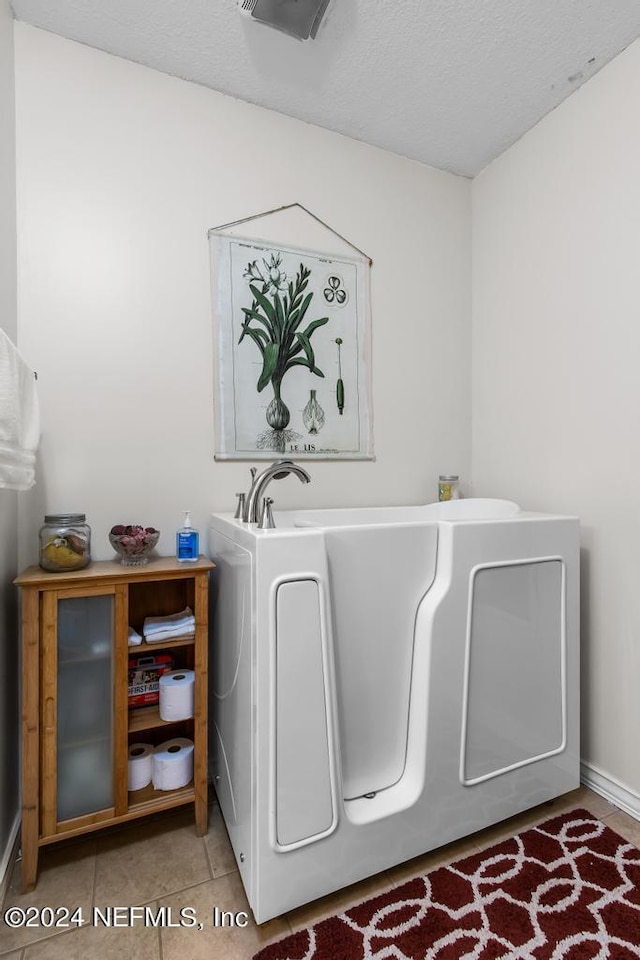 laundry room featuring tile patterned floors, visible vents, laundry area, and a textured ceiling
