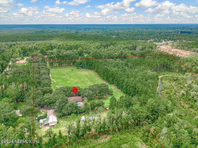 drone / aerial view with a wooded view and a rural view