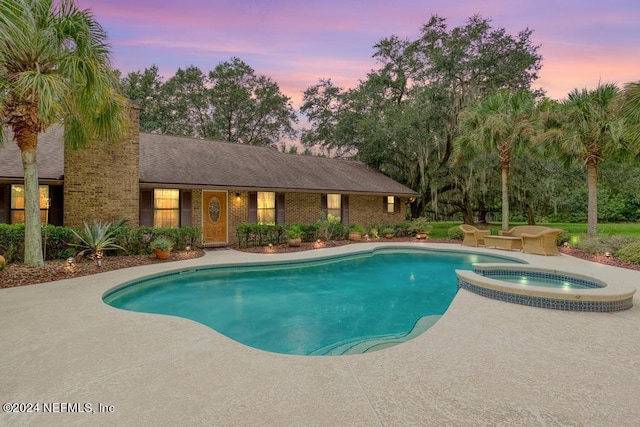 view of swimming pool with a patio and a pool with connected hot tub