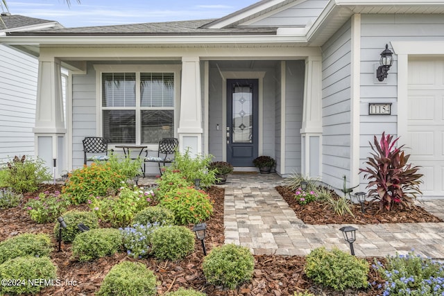 property entrance featuring a garage and a porch