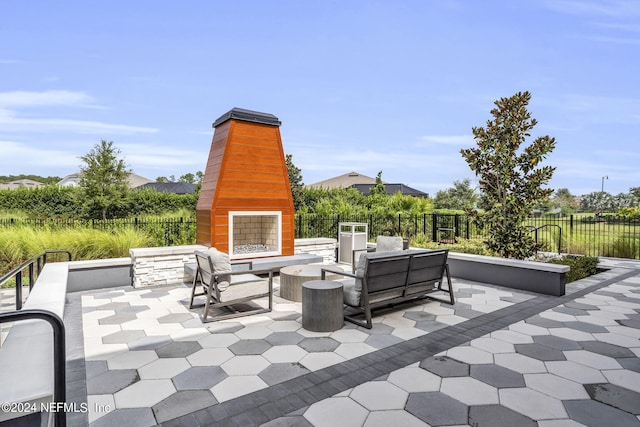 view of patio with an outdoor living space with a fireplace